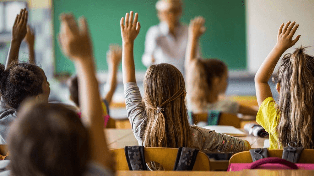 Élèves en classe levant la main